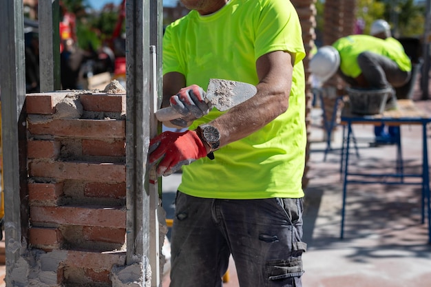 bricklayer-working-brick-construction-site-with-trowel-level-bricks-cement_843561-1529.jpg